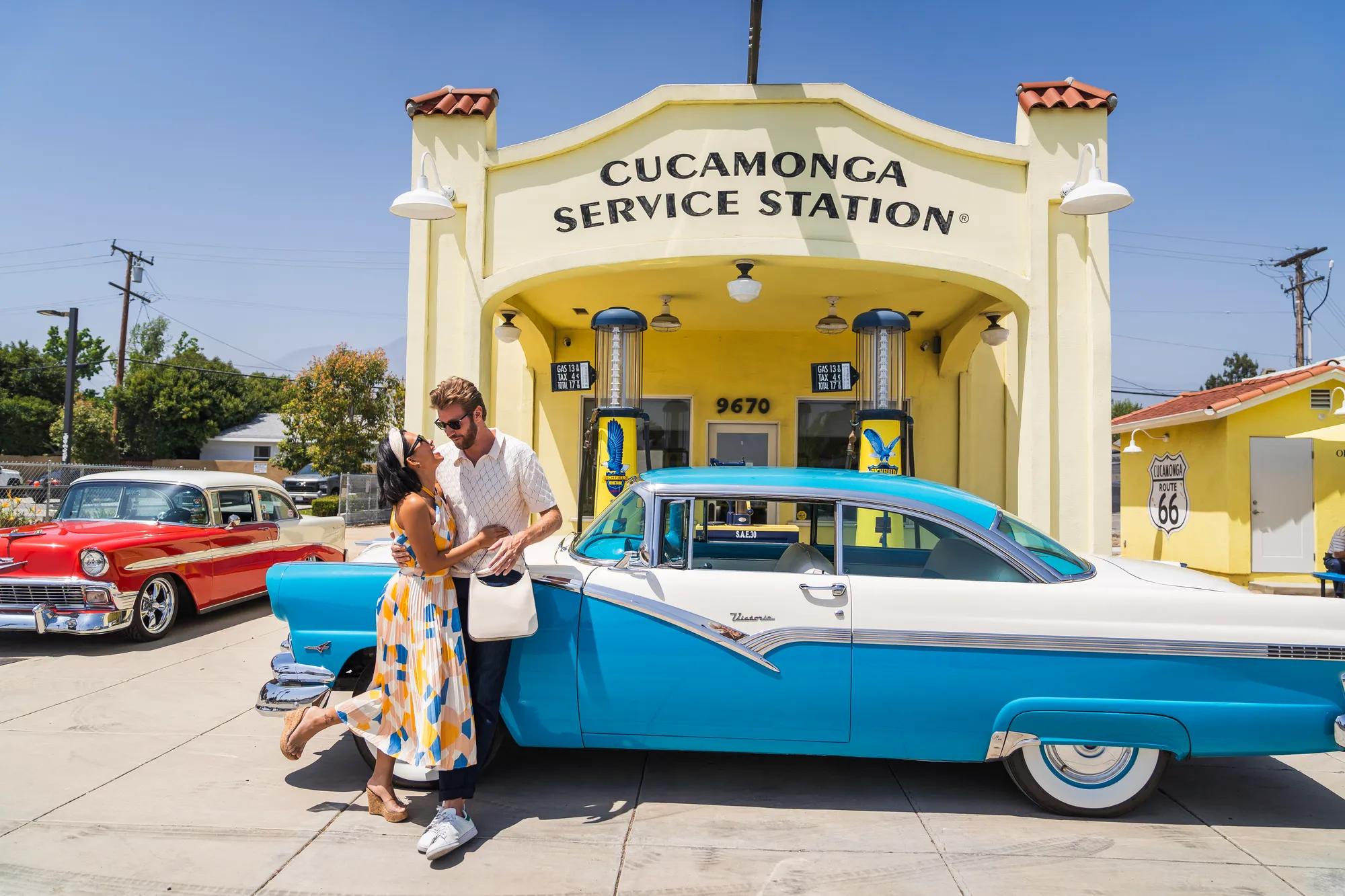 Couple in front of the exterior of the Cucamona Service Station the Historic site along Route 66.