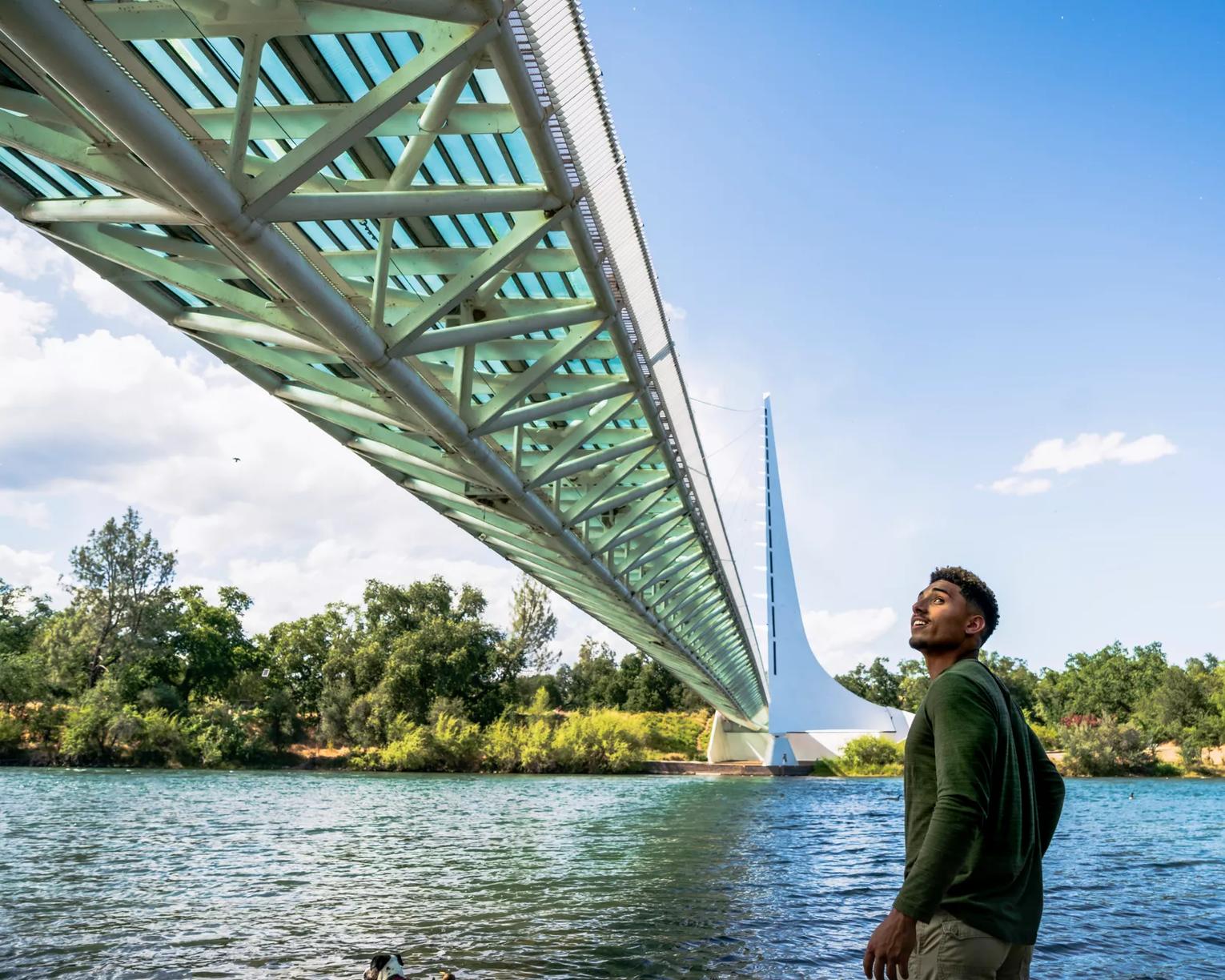 Man walking across Sundial Bridge in Redding, California in the afternoon