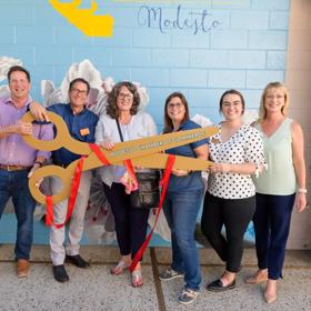 Modesto California Welcome Center Staff and Office of Tourism Manager Tori Cruz-Tuchs cut the ribbon for the new welcome center
