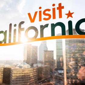 The Visit California PME East Coast Road Show at Raffles Hotel in Boston, Massachusetts on November 7, 2023: The Visit California logo window decal with the Boston skyline in the background