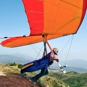 Stock image by Tony Garcia taken in June 2014.
Hang glider prepares for takeoff over grassy cliffs.