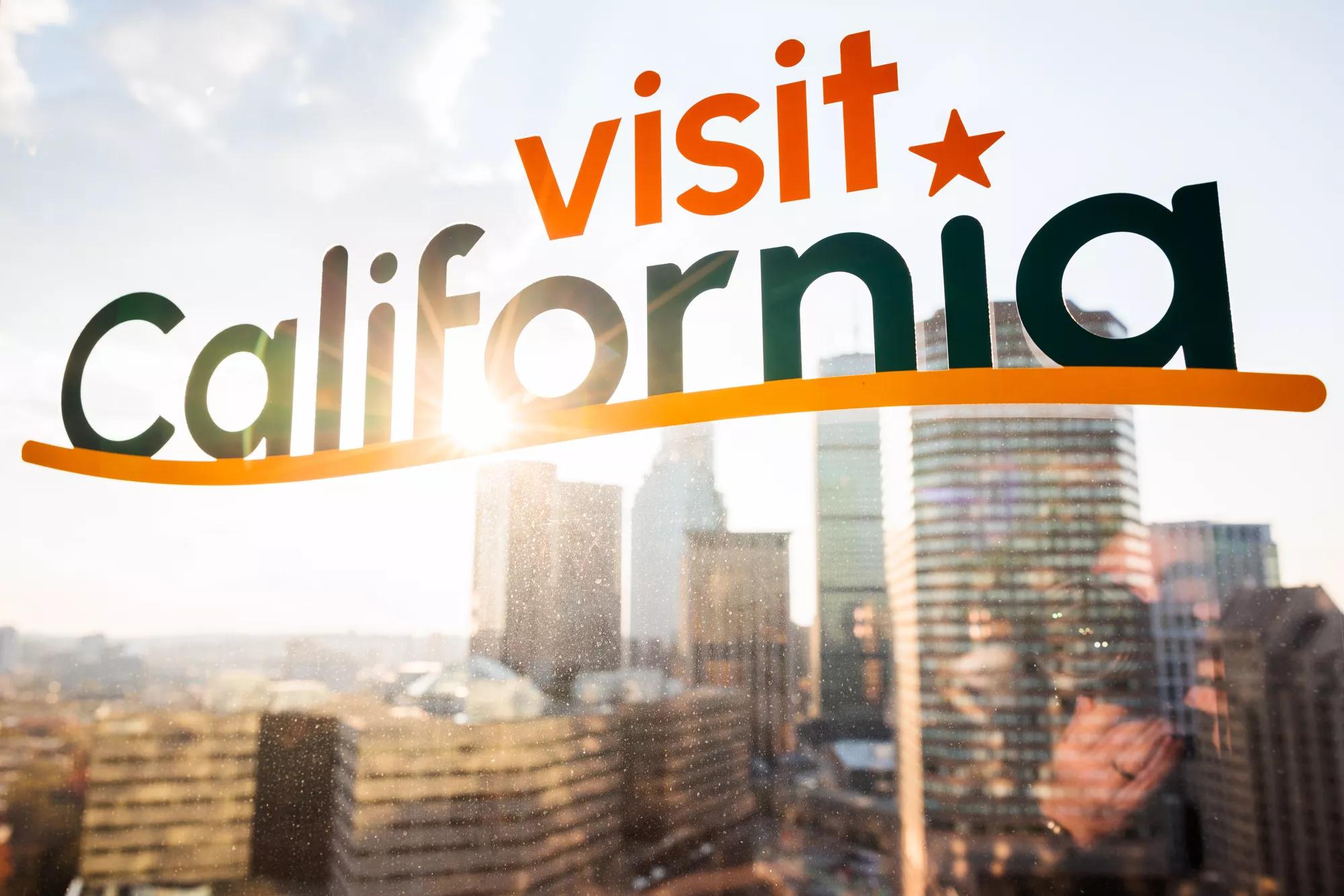 The Visit California PME East Coast Road Show at Raffles Hotel in Boston, Massachusetts on November 7, 2023: The Visit California logo window decal with the Boston skyline in the background